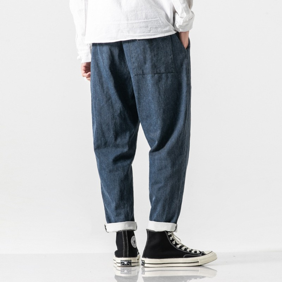 Person wearing blue pokku pants and black high-top sneakers on a white background