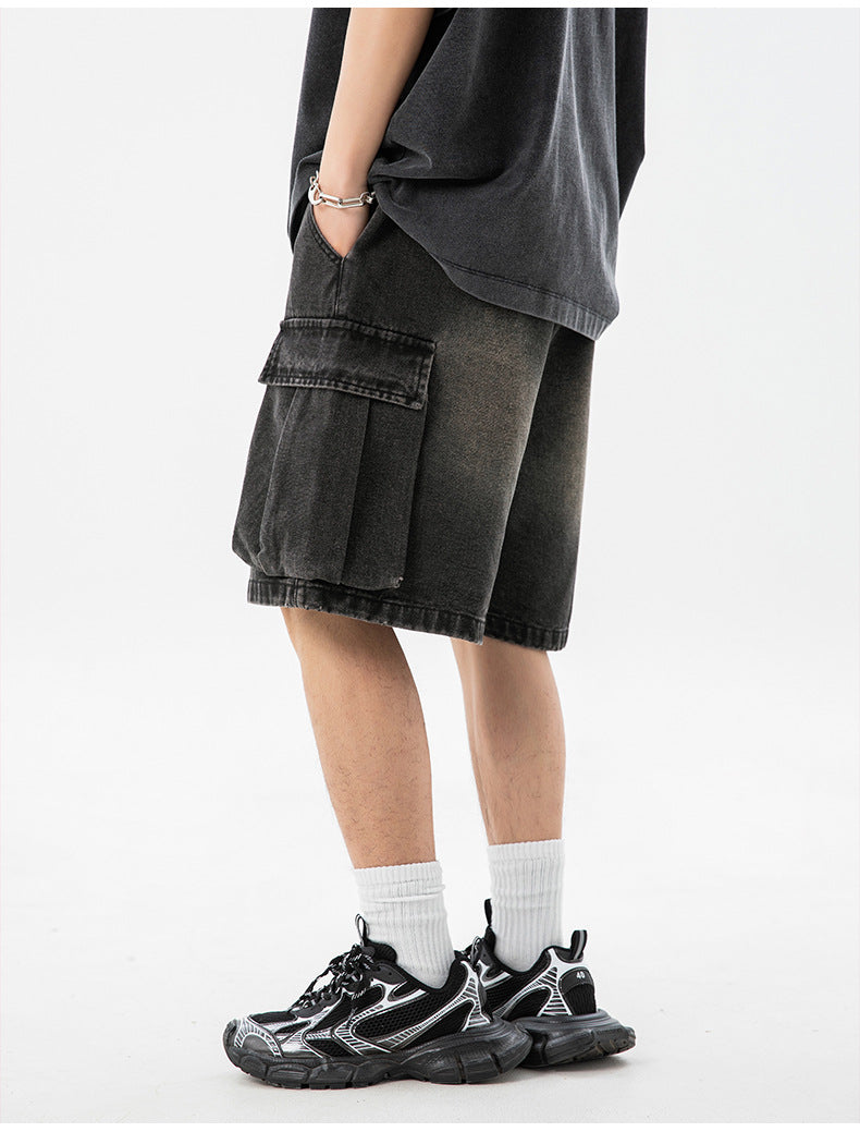 Person wearing black cargo shorts and black sneakers on a white background